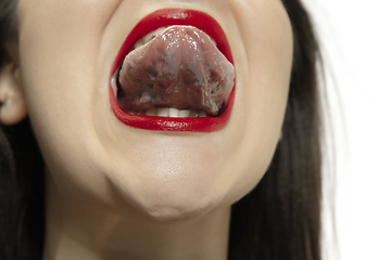 Image showing Smiling girl opening her mouth with red lips and showing the long big giant tongue isolated on white background, crazy and attracted, close up