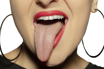 Image showing Smiling girl opening her mouth with red lips and showing the long big giant tongue isolated on white background, crazy and attracted, close up