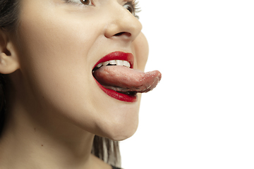 Image showing Smiling girl opening her mouth with red lips and showing the long big giant tongue isolated on white background, crazy and attracted, close up