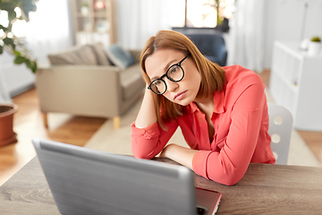 Image showing bored woman with laptop working at home office