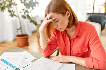 Image showing stressed woman with papers working at home office