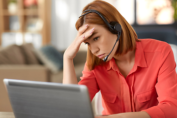 Image showing sad woman with headset and laptop working at home