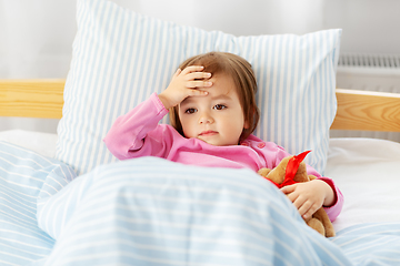 Image showing sick little girl lying in bed at home