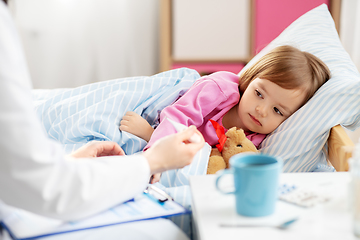 Image showing doctor measuring sick girl's temperature at home