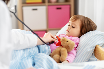 Image showing doctor with stethoscope and sick girl in bed