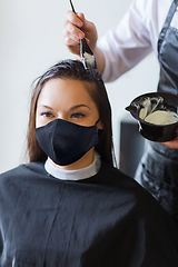 Image showing happy woman with stylist coloring hair at salon