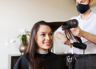 Image showing happy woman with stylist making hairdo at salon