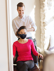 Image showing happy woman with stylist making hairdo at salon