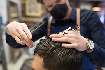 Image showing male hairdresser cutting hair at barbershop