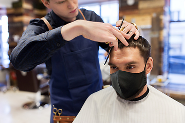 Image showing man and barber cutting hair at barbershop