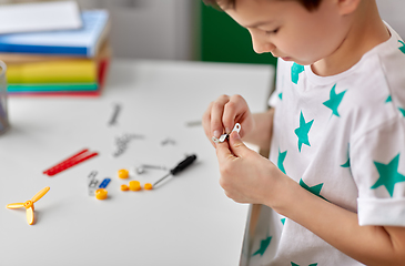 Image showing happy little boy playing with airplane toy at home