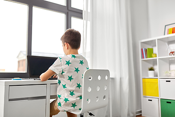 Image showing student boy typing on laptop computer at home