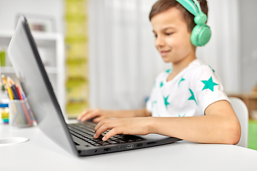 Image showing boy in headphones playing video game on laptop