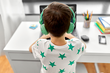 Image showing boy in headphones playing video game on laptop