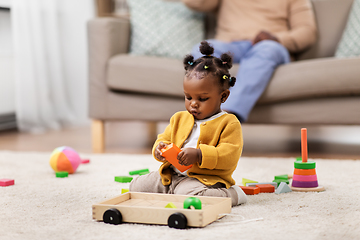 Image showing african baby girl playing with toy blocks at home