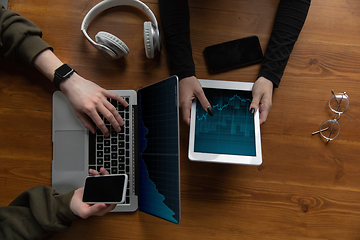 Image showing Close up of two people, couple using smartphone, laptop, smartwatch, education and business concept. Communication during self-insulation, top view, copyspace