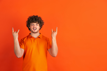 Image showing Caucasian young man\'s monochrome portrait on orange studio background