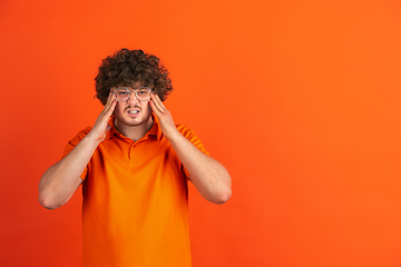 Image showing Caucasian young man\'s monochrome portrait on orange studio background