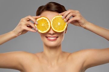 Image showing beautiful woman making eye mask of orange slices