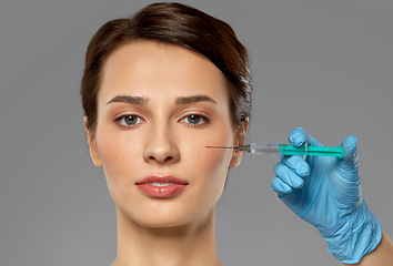 Image showing beautiful young woman and hand with syringe