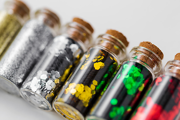 Image showing set of glitters in bottles over white background