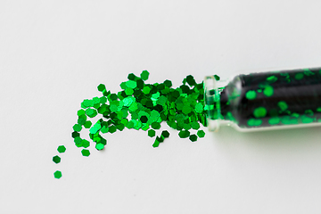 Image showing green glitters poured from small glass bottle