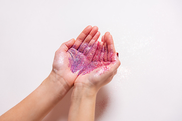 Image showing hands holding glitters on white background
