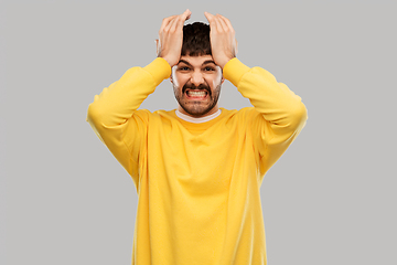 Image showing angry young man holding to head