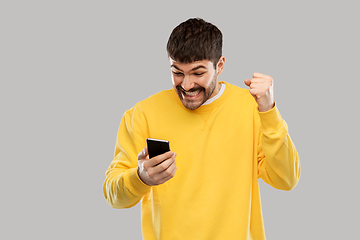 Image showing happy smiling young man with smartphone