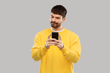 Image showing puzzled young man with smartphone