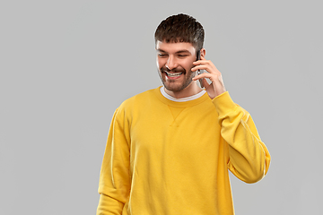 Image showing happy smiling young man calling on smartphone