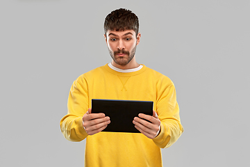 Image showing surprised young man with tablet pc computer