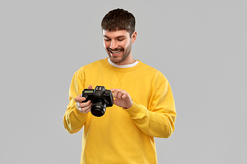 Image showing smiling young man with digital camera