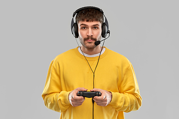 Image showing man with headset and gamepad playing video game