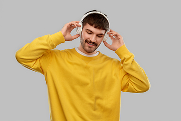 Image showing happy young man in headphones listening to music