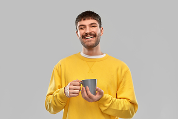 Image showing happy smiling young man with coffee cup