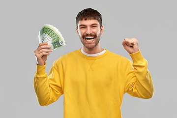 Image showing happy young man with money celebrating success