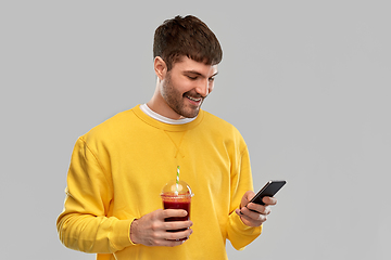 Image showing happy man with smartphone and tomato juice