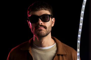 Image showing man in sunglasses over neon lights at nightclub