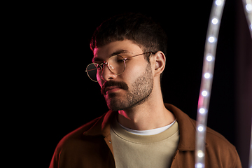 Image showing man in glasses over neon lights at nightclub