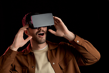 Image showing surprised man in vr glasses over black background