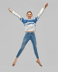 Image showing smiling teenage girl in pullover jumping