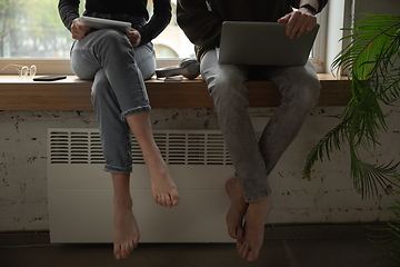 Image showing Close up of two people, couple using smartphone, laptop, smartwatch, education and business concept, communication during self-insulation