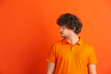 Image showing Caucasian young man\'s monochrome portrait on orange studio background