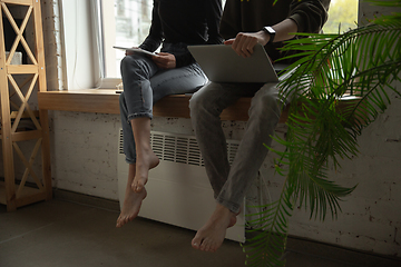 Image showing Close up of two people, couple using smartphone, laptop, smartwatch, education and business concept, communication during self-insulation