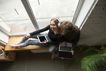 Image showing Attractive young couple using devices together, tablet, laptop, smartphone, headphones wireless. Gadgets and technologies connecting people all around the world. Top view