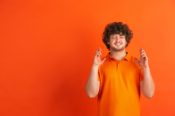 Image showing Caucasian young man\'s monochrome portrait on orange studio background