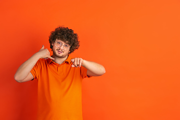 Image showing Caucasian young man\'s monochrome portrait on orange studio background