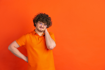 Image showing Caucasian young man\'s monochrome portrait on orange studio background