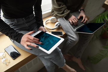 Image showing Close up of two people, couple using smartphone, laptop, smartwatch, education and business concept, communication during self-insulation